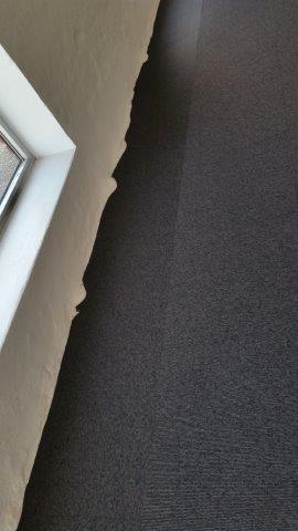 Tæppefliser skåret til rå væg